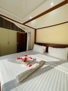 a bed with two towels and flowers on it at Linda's Little Lincoln in Watamu +58 photos
