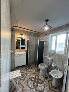 un baño con inodoro y lavabo en Departamento ILANAHO, en La Falda