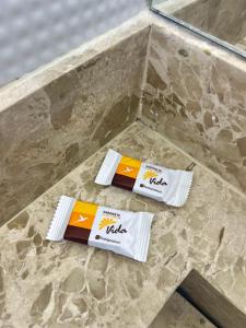 two packets of toilet paper sitting on a marble floor at Pousada Velho Brito in Piranhas