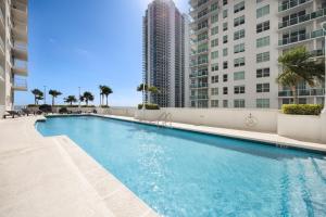 a large swimming pool with tall buildings in the background at Two Bedroom Oceanview Apartment in Brickell in Miami