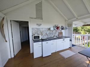 Una cocina con gabinetes blancos y una estufa. en Bungalow Villa-Déhé, en Deshaies