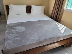 a large bed in a room with at Kaira kunda guesthouse in Nimsat