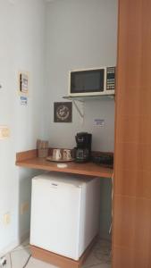 a kitchen with a counter with a microwave and a refrigerator at Condomínio Thermas Place in Caldas Novas +8 photos