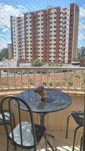 a table and chairs on a balcony with buildings at Condomínio Thermas Place in Caldas Novas