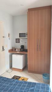 a room with a kitchen with a large wooden cabinet at Condomínio Thermas Place in Caldas Novas