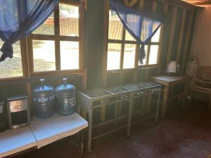 a room with two large bottles on a table with windows at Eko Aldea Kolybry in San Joaquín