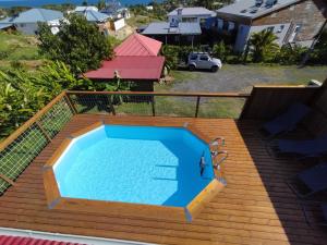 a large swimming pool on a deck next to a house at Ambre et Azur 2 in Sainte-Rose