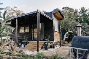 a small house with a black exterior at Sandy Hill Forest Tiny Home in Yankalilla