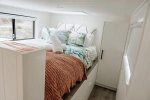 una piccola camera da letto con un letto e una finestra di Sandy Hill Forest Tiny Home a Yankalilla