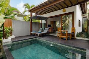 a house with a swimming pool and a patio at Elitya Ubud Villa in Ubud