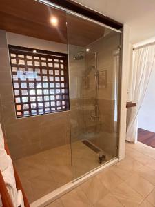 a shower with a glass door in a bathroom at Red Garden Resort in Eluan