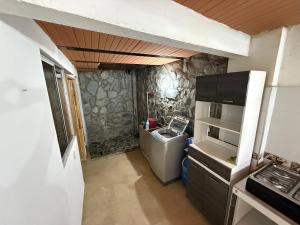 Una pequeña cocina con estufa y refrigerador. en Apartamento campestre 102, en Ibagué