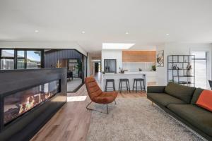 a living room with a couch and a fireplace at Heated Pool Gym Sauna Hot Tub in Taupo +18 photos