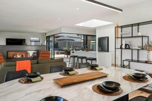 a dining room with a table and a living room at Heated Pool Gym Sauna Hot Tub in Taupo