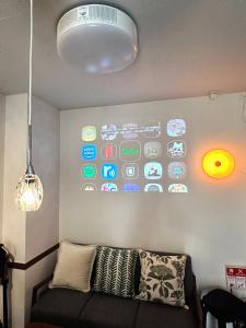 名古屋市にあるDomus OZONEのソファ付きの部屋、壁にたくさんのアプリが備わります。