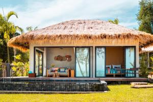 a house with a thatched roof with a patio at JATI Koh Russey in Sihanoukville