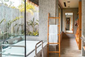 a bathroom with a bath tub and a window at JATI Koh Russey in Sihanoukville