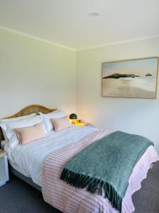 a bedroom with a large bed with pink pillows at Mount Central Hideaway in Mount Maunganui
