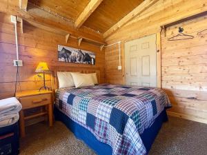 マウント・カーメルにあるThe Park Cabin at Mount Carmel Motel and RV Parkの木造キャビン内のベッド1台が備わるベッドルーム1室を利用します。