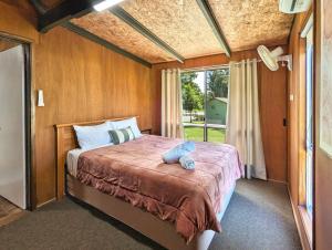 una camera da letto con un grande letto e una finestra di Gumnut Glen Cabins a Yeppoon