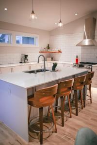 a kitchen with a large island with wooden bar stools at Courtenay Luxe Suite in Courtenay +10 photos