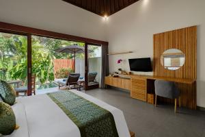 a bedroom with a bed and a television and a patio at Elitya Ubud Villa in Ubud