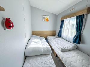 a small room with two beds and a window at Lovely 8 Berth Caravan At Manor Park Nearby Hunstanton Beach 23107S in Hunstanton +17 photos