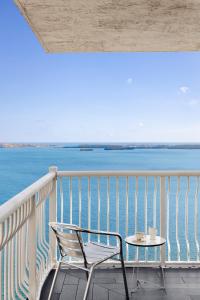 a chair and a table on a balcony overlooking the water at Brickell Apartments with Oceanview in Miami