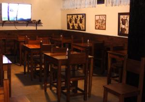 a restaurant with wooden tables and chairs and a television at Hotel Medina y Mar BnB in Mar del Plata