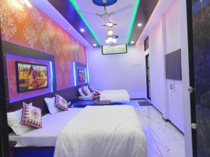 two beds in a room with purple lights at Natkhat Homestay in Garudeshwar