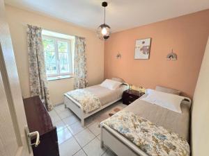 Un dormitorio con dos camas y una ventana. en Gîte de charme avec cheminée en Dordogne - FR-1-616-466, en Tourtoirac