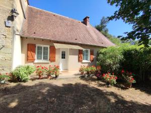 una pequeña casa blanca con flores delante en Gîte de charme avec cheminée en Dordogne - FR-1-616-466, en Tourtoirac