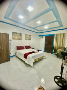a bedroom with a large bed in a room with blue ceilings at Lens Staycation 1-BDR-BR-KTCHN in PANABO in Panabo