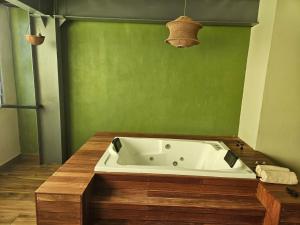 a bath tub in a bathroom with a green wall at Camping con jacuzzi en la ciudad in San Baltasar