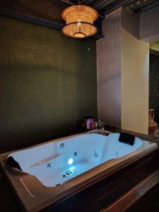 a large bath tub in a bathroom with a chandelier at Camping con jacuzzi en la ciudad in San Baltasar