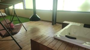 a bath tub in a room with a wooden floor at Camping con jacuzzi en la ciudad in San Baltasar