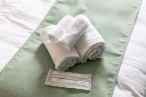 a pair of towels and a thermometer on a bed at USP HOTEL Shinimamiya in Osaka