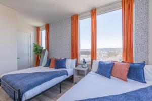 two beds in a room with a large window at Vibrant Visit near Airport, Free Parking, 2 BR 2 Bath Suite that Sleeps 8, 20 Percent OFF 7 days in East Orange +41 photos