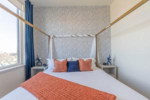 a bedroom with a bed with orange and blue pillows at Vibrant Visit near Airport, Free Parking, 2 BR 2 Bath Suite that Sleeps 8, 20 Percent OFF 7 days in East Orange