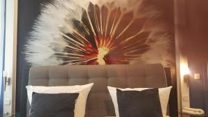 a painting of a flower is above a bed at Hotel Werratal in Bad Sooden-Allendorf