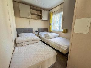 ハンスタントンにあるLovely Caravan With Decking At Manor Park In Hunstanton Ref 23091Tの窓のある小さな部屋にベッドが2つある +12枚の写真
