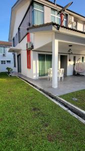 a house with a patio with a table and chairs at MeRiz Islamic Homestay, Bukit Beruntung in Kampung Sungia Buaya