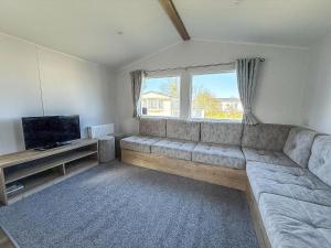sala de estar con sofá grande y TV en Lovely 8 Berth Caravan Ref 23028B, en Hunstanton
