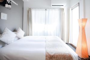 a bedroom with a large white bed and a window at Base in Kyoto Hanazono in Kyoto +73 photos