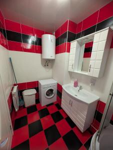 Stylish apartment في كيشيناو: حمام احمر وبيض مع مغسلة وغسالة ملابس