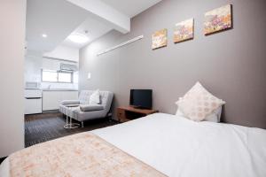a bedroom with a white bed and a chair at Base in Kyoto Hanazono in Kyoto