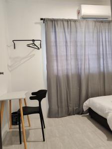 ein Schlafzimmer mit einem Bett, einem Stuhl und einem Vorhang in der Unterkunft 23 Inn Singlebed Room with share bathroom in Bukit Mertajam + 13 Fotos