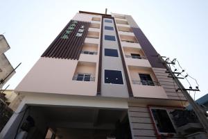 a tall white building with balconies on it at Aadya Inn New Luxury Hotel in Tirupati