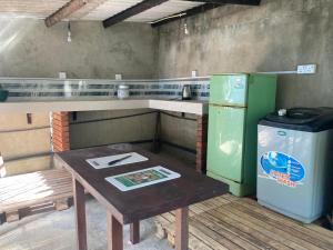 a small kitchen with a table and a refrigerator at Banana Leaf Garden in Weligama +16 photos