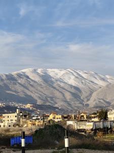 una montaña cubierta de nieve en el fondo de una ciudad en סוויטת לורד הרמיטאז' בגלון, en Bruchim
